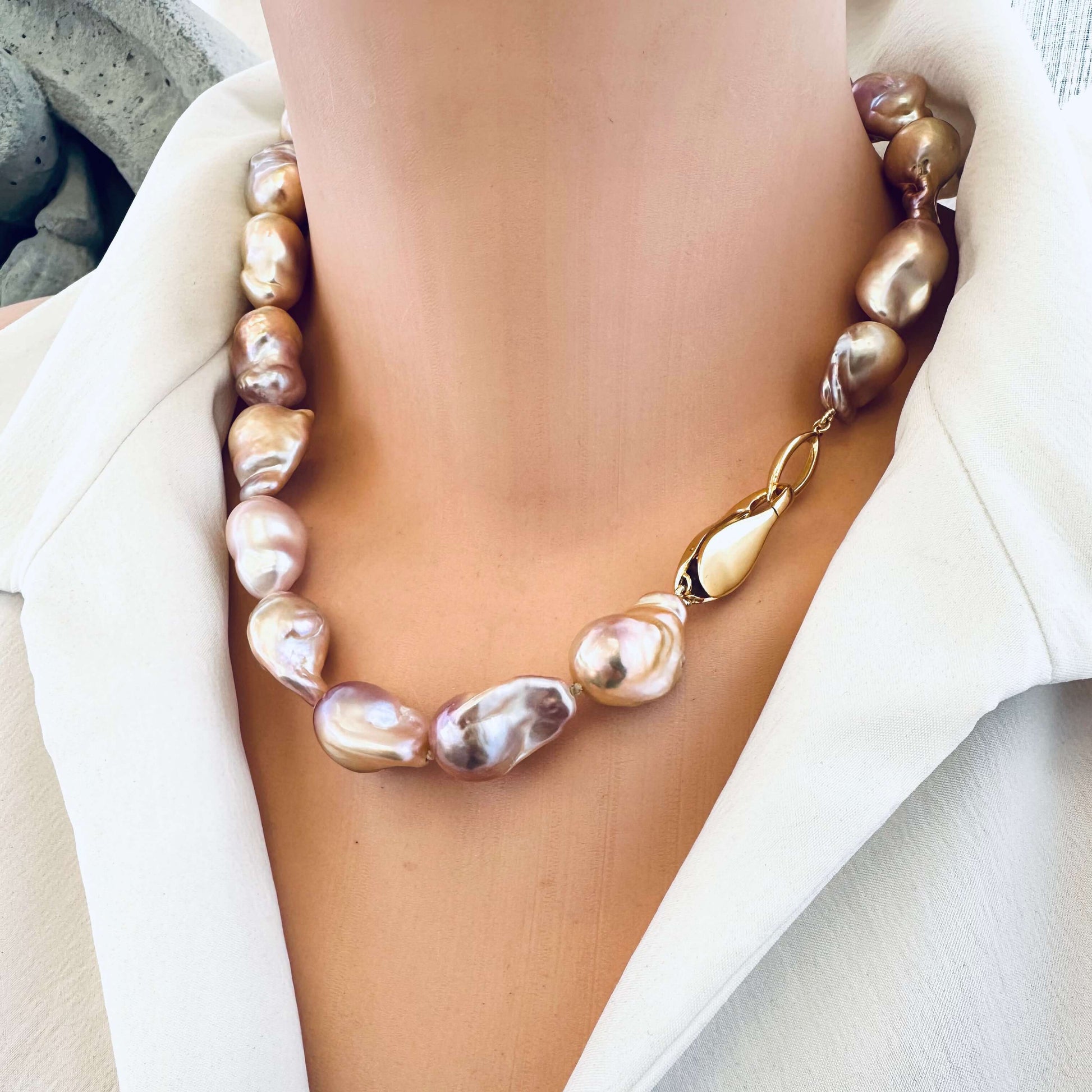 Golden pink baroque pearl necklace displayed on mannequin, handmade jewelry