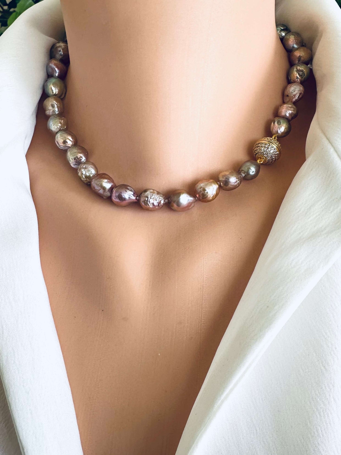 Necklace with pink metallic lustre pearls on a white background