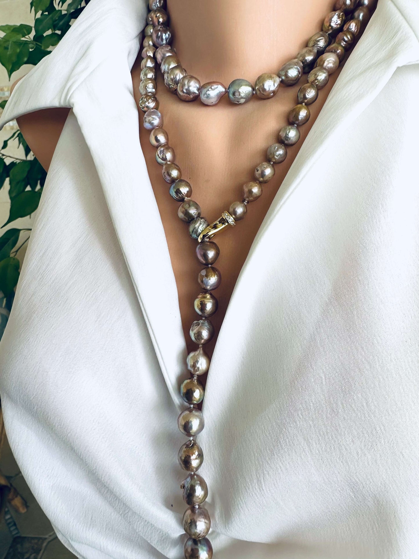 Pearl necklace draped over a white blouse with a blurred background