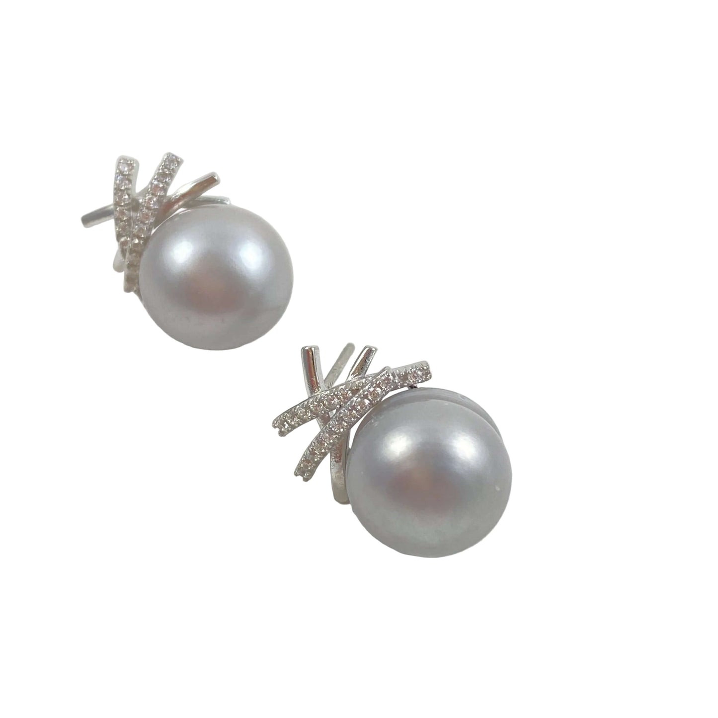 A pair of silver stud earrings featuring a large, round gray pearl set in a silver leaf-like halo with small clear stones, shown on a light gray background.
