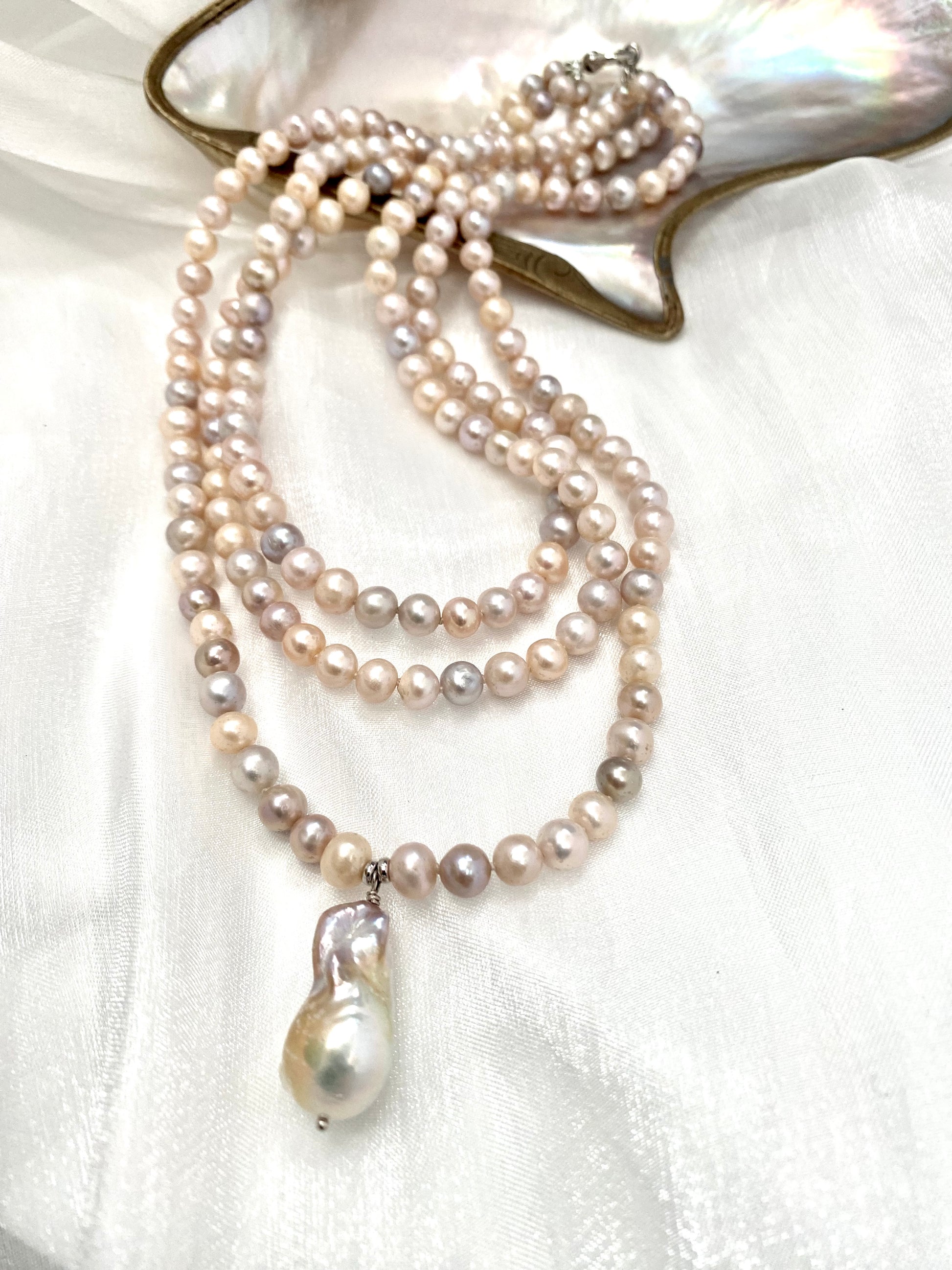 Pearl necklace with a pendant on a white fabric background