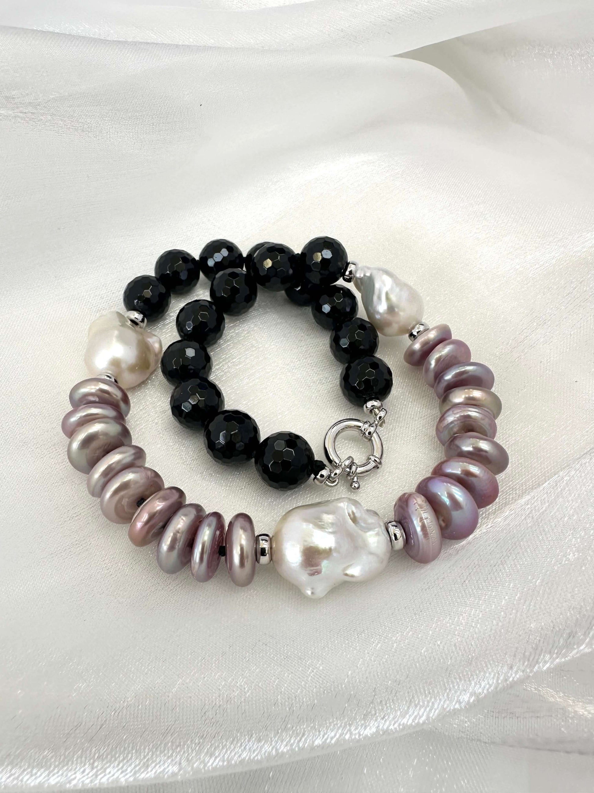 Close up of baroque pearl necklace with black tourmaline beads and purple coin pearls