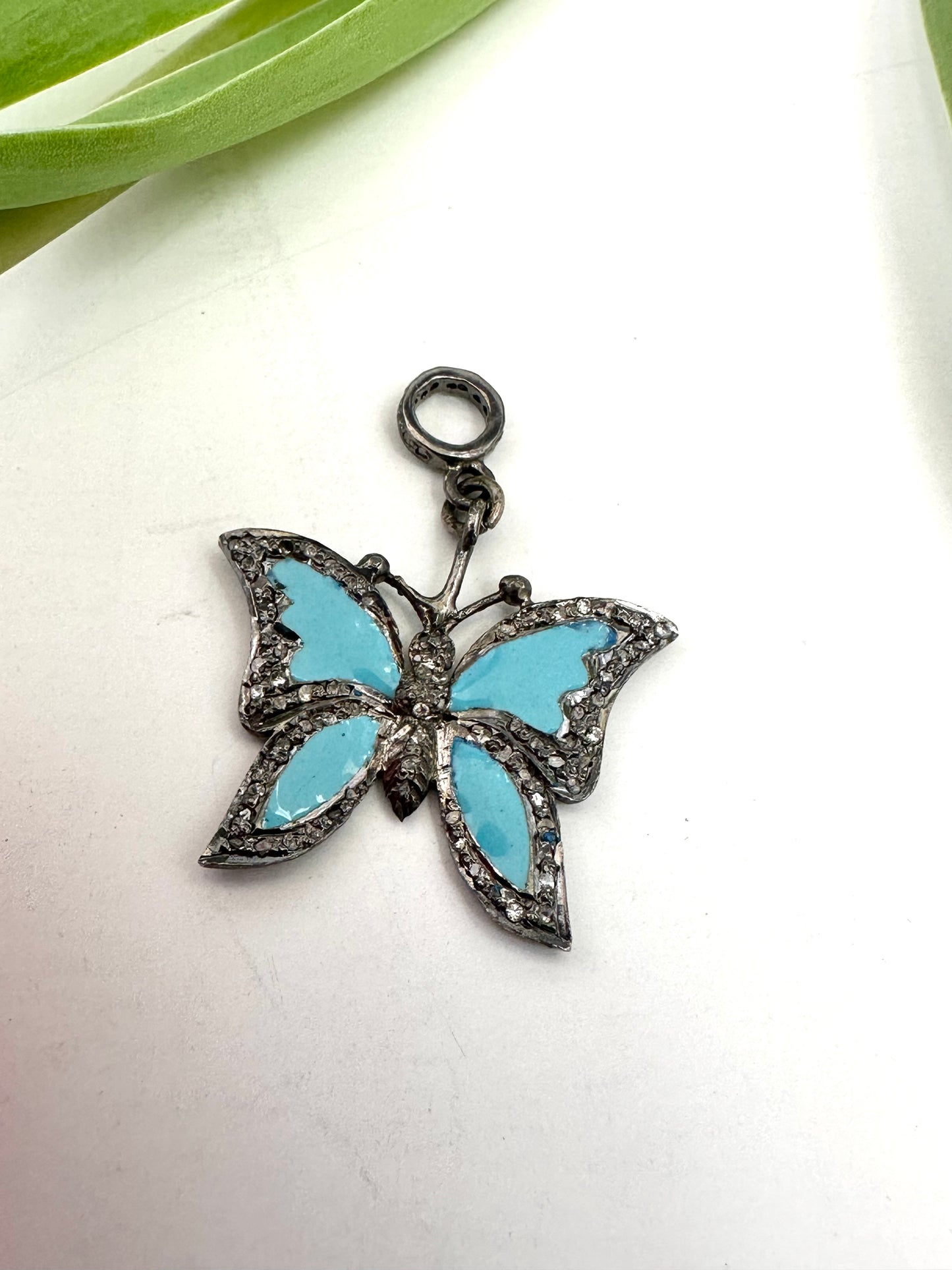 Butterfly-shaped pendant with blue wings on a white background