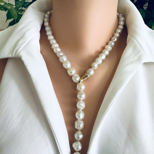 Edison pearl Y necklace featuring baroque pearls displayed elegantly along the neckline of a white shirt.