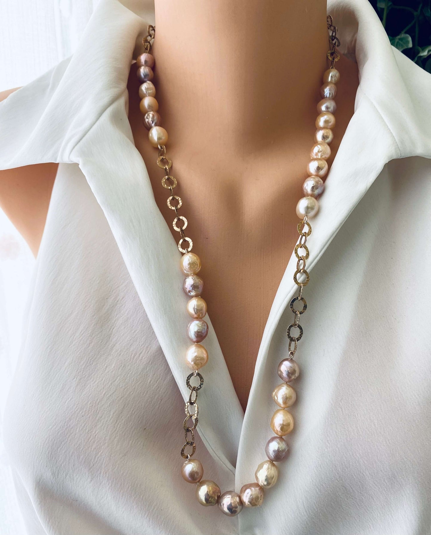Edison pearl necklace with wrinkled pearls displayed on a mannequin wearing a white blouse, showcasing elegance.