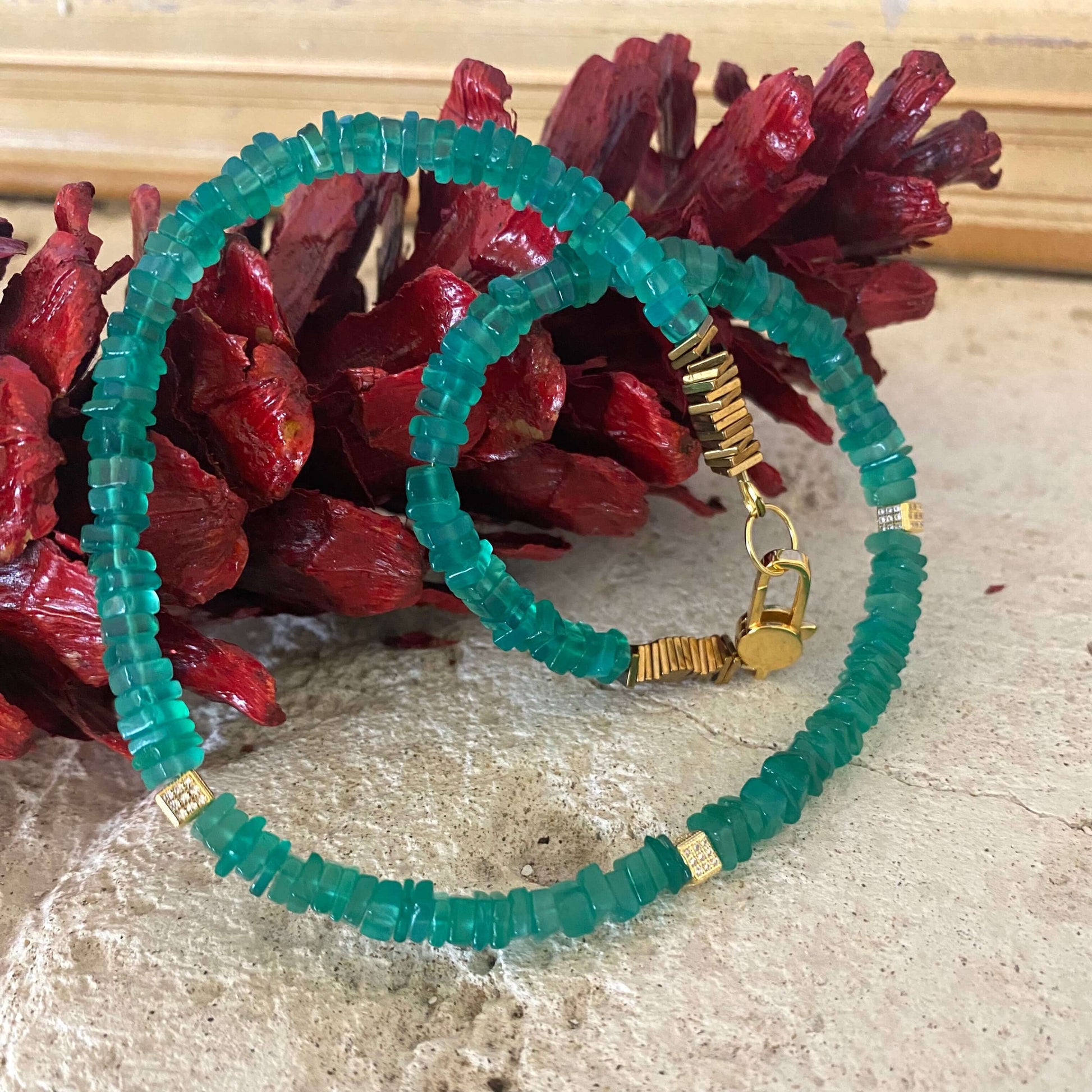 Green onyx choker necklace displayed flat with matching green gemstone jewelry