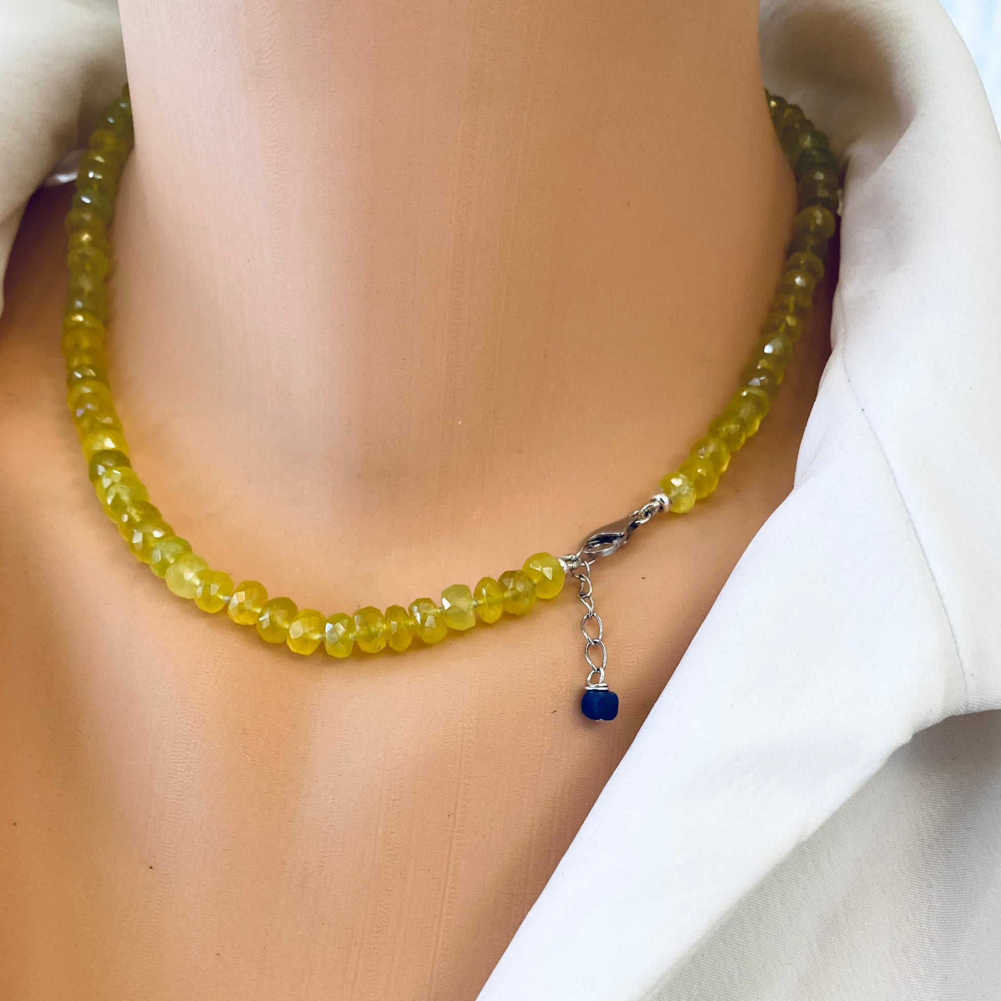 Handmade yellow green chalcedony necklace worn on a mannequin, featuring bright yellow-green gemstones and a unique clasp.