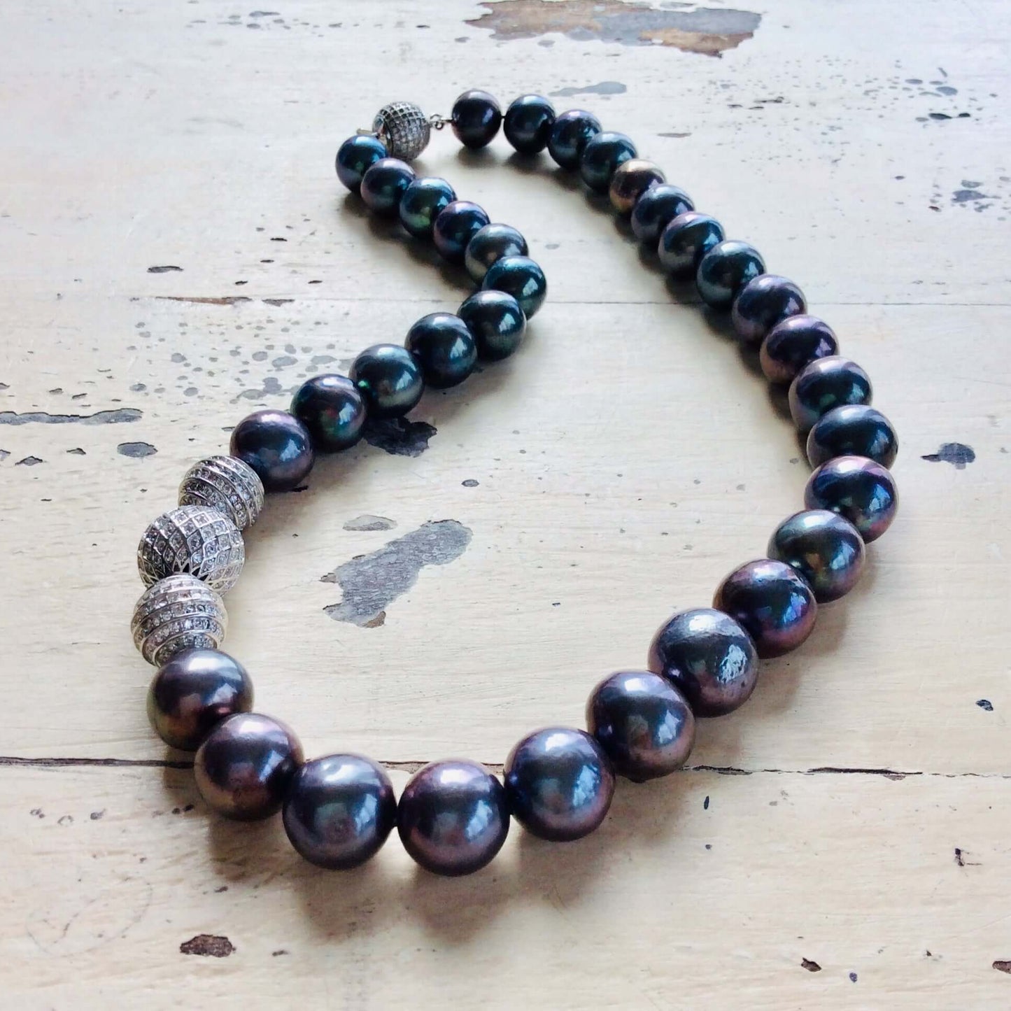 Elegant black pearl silver necklace displayed on white wooden table showcasing sterling silver and CZ accents
