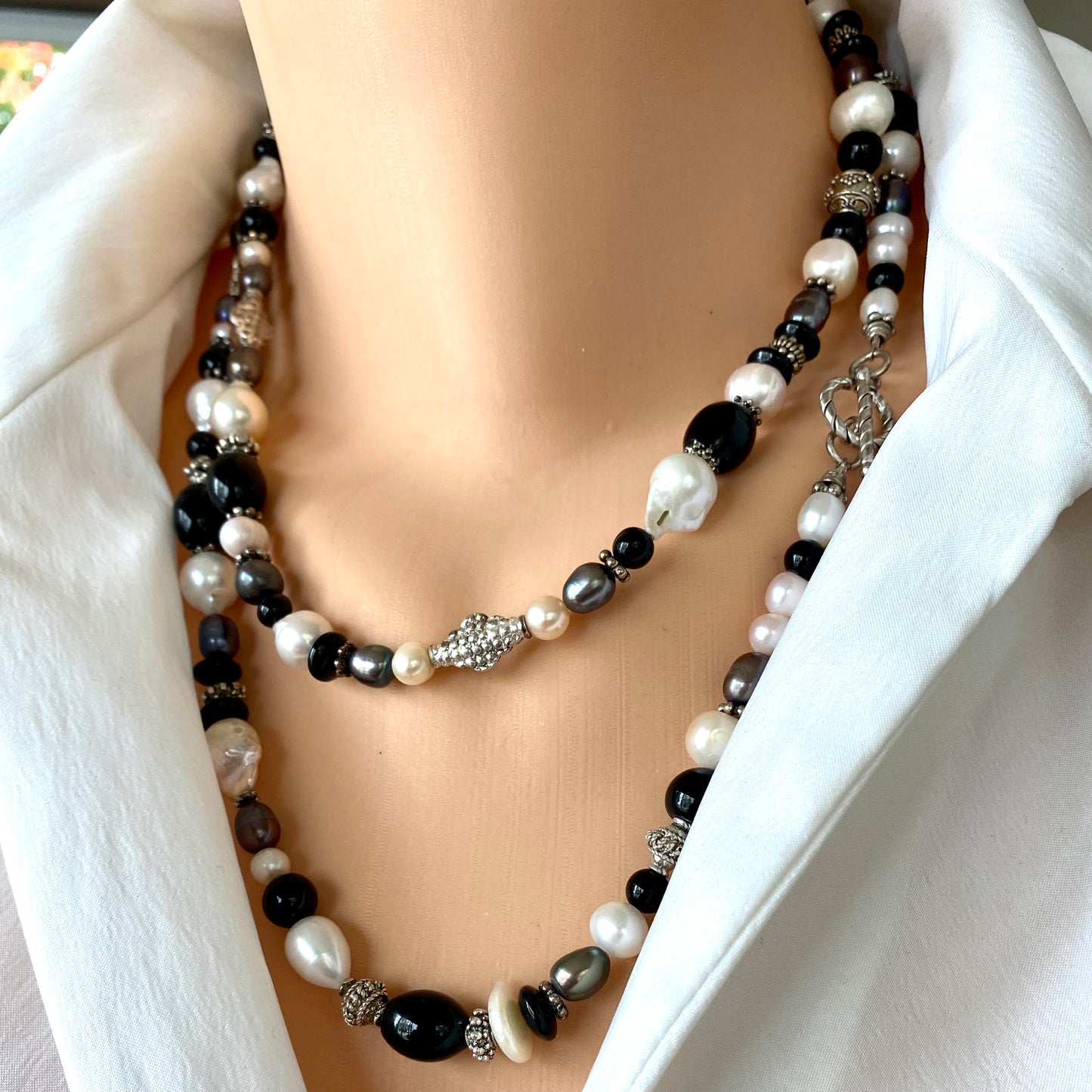 Black onyx pearl long necklace worn at the neckline with black onyx beads and white baroque pearls