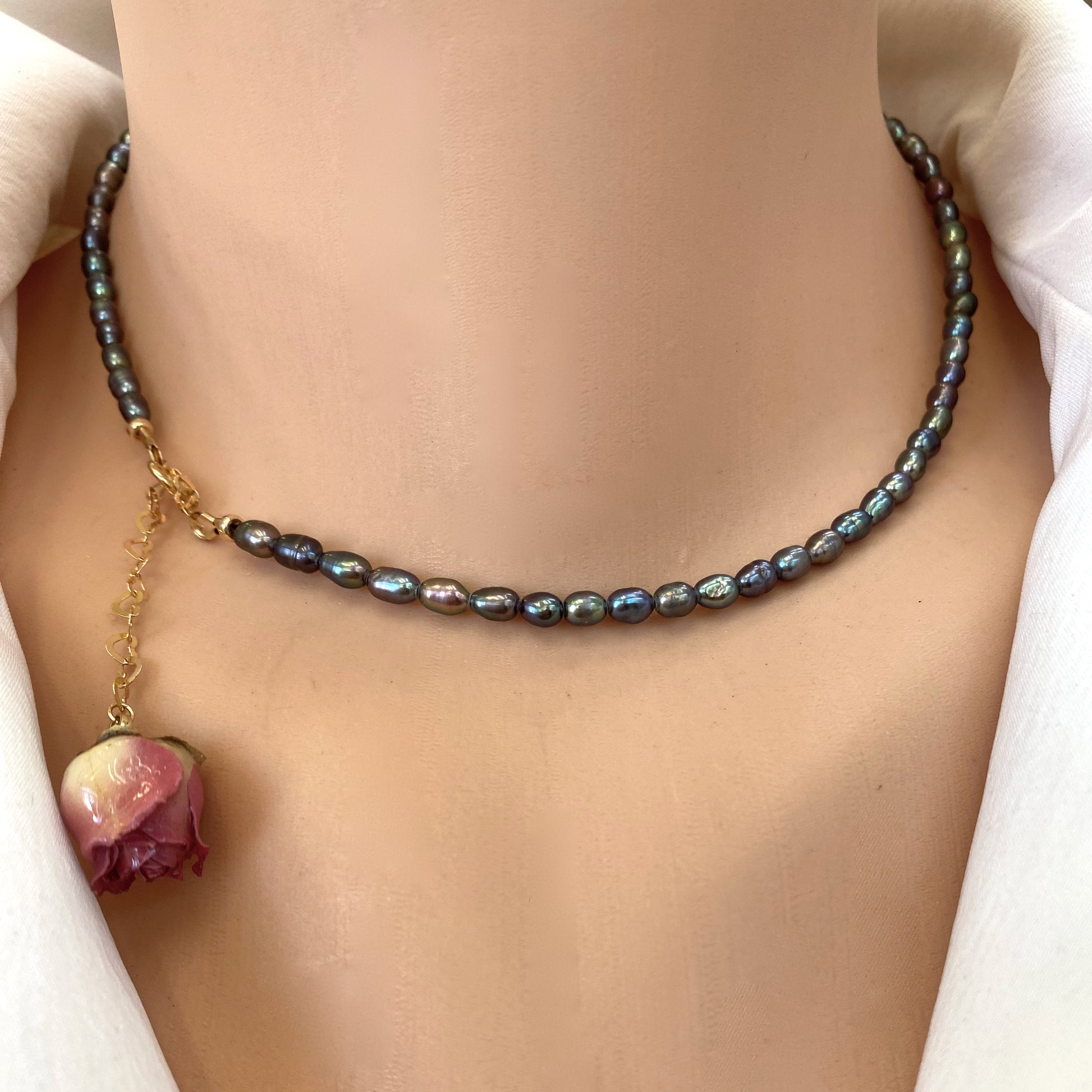 Pink Rosebud Pearl Necklace featuring black rice pearls and a preserved pink rosebud charm.