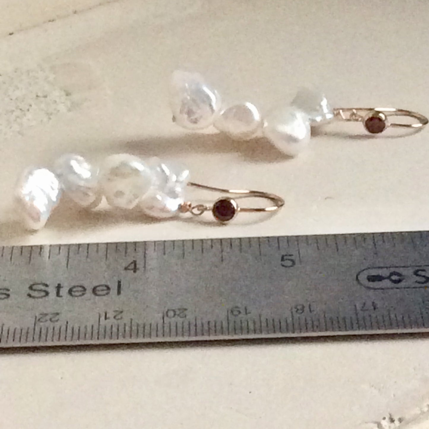 Pearl drop earrings featuring luminous keshi pearls and red CZ, handmade in Canada.