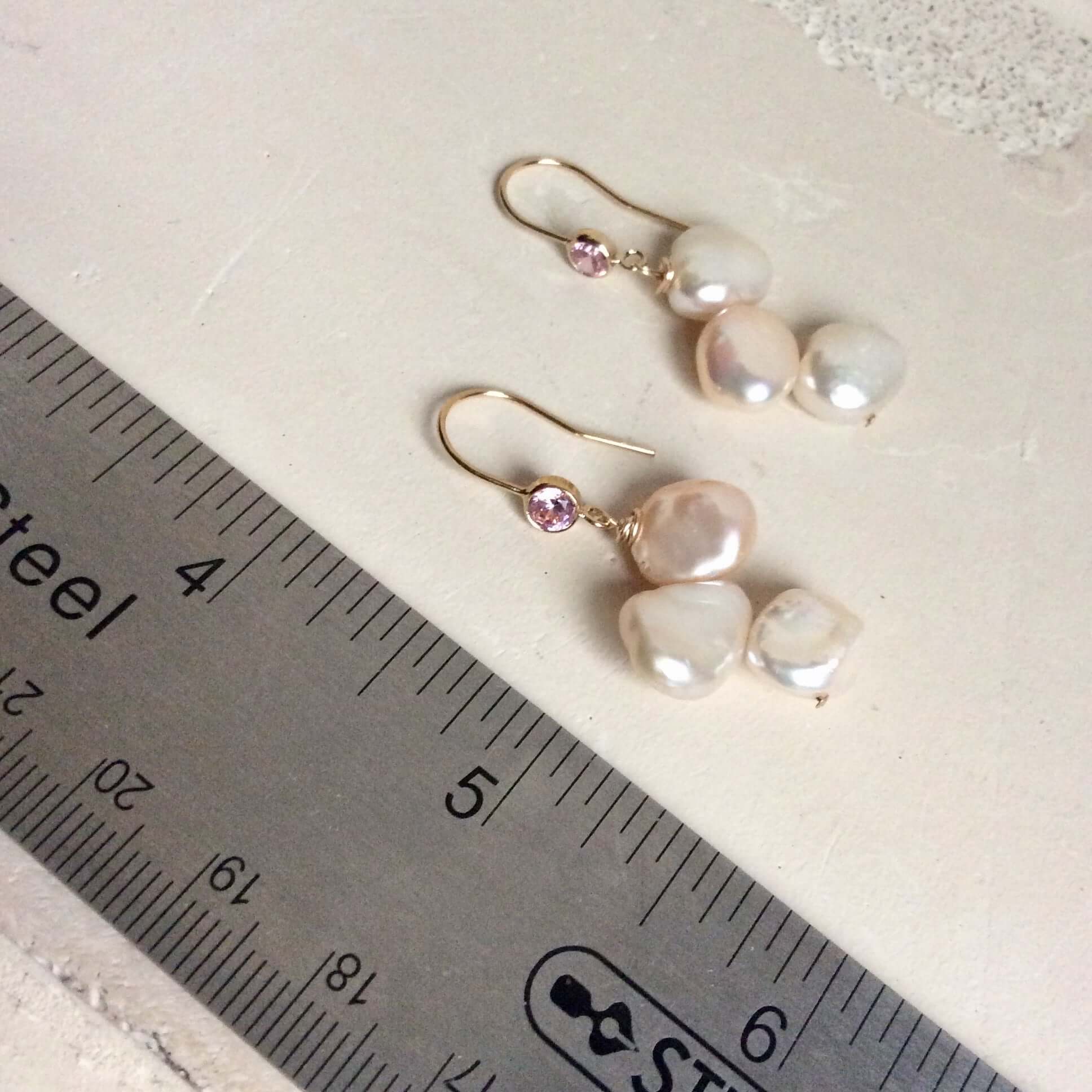 Elegant earrings composed of Natural Keshi pink and white pearls hanging from gold filled hooks with pink cubic zirconia bezel
