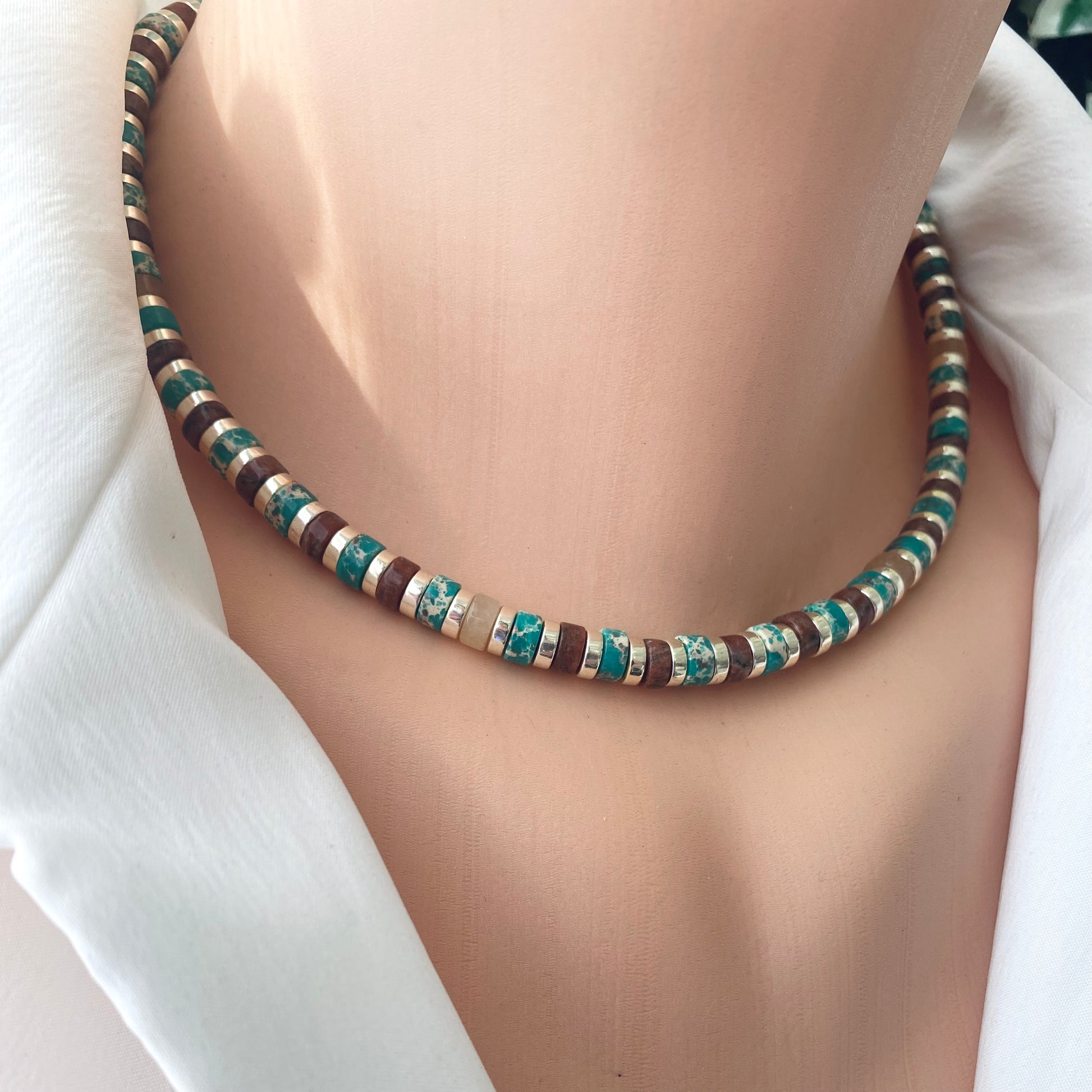 Gemstone choker necklace with multi color beads and hematite showcasing vibrant tube-shaped beads on a mannequin.