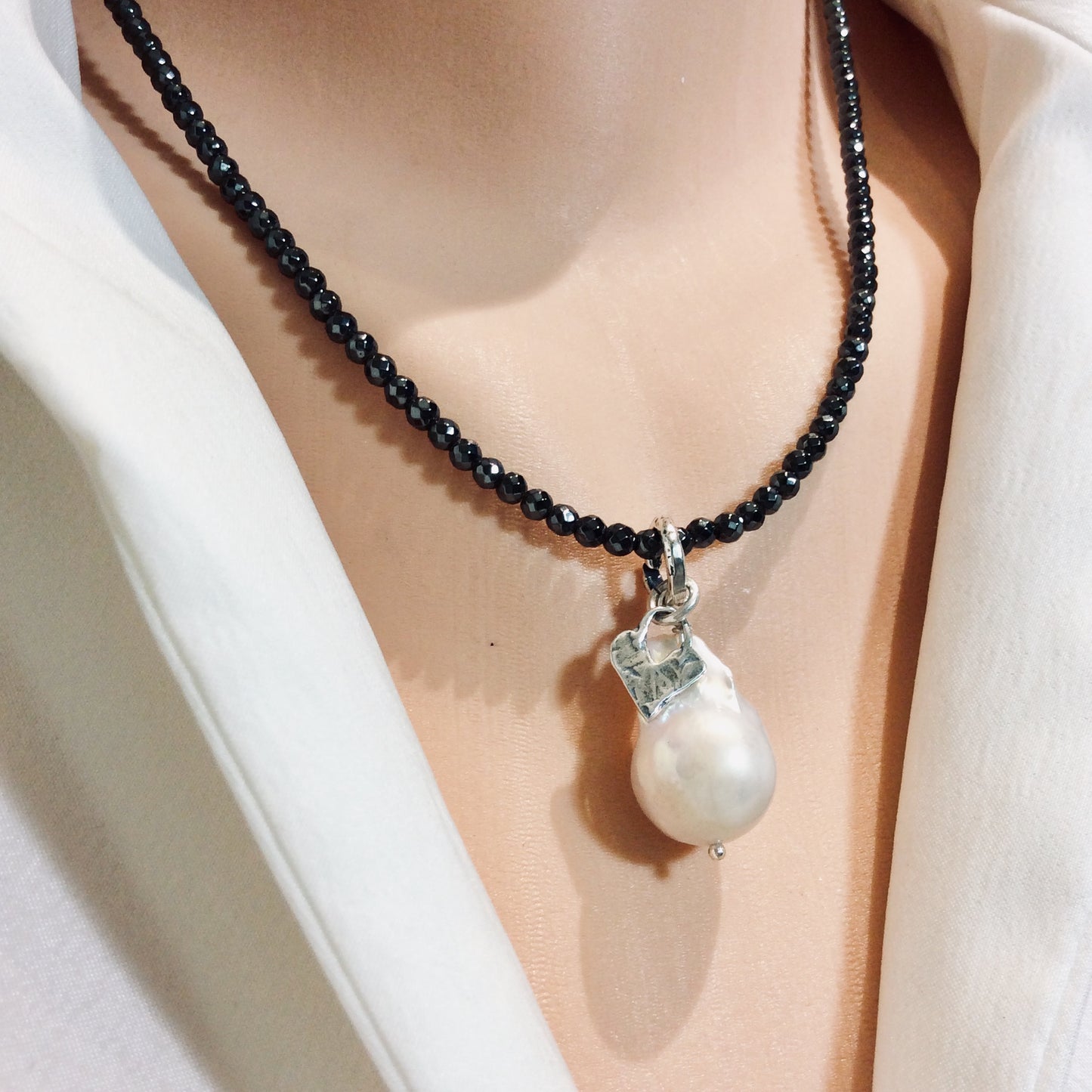 Hematite necklace with baroque pearl pendant styled simply for everyday wear