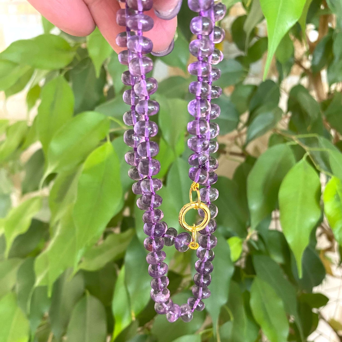 Amethyst candy necklace featuring Brazilian amethyst beads with a golden clasp, showcasing deep violet tones.