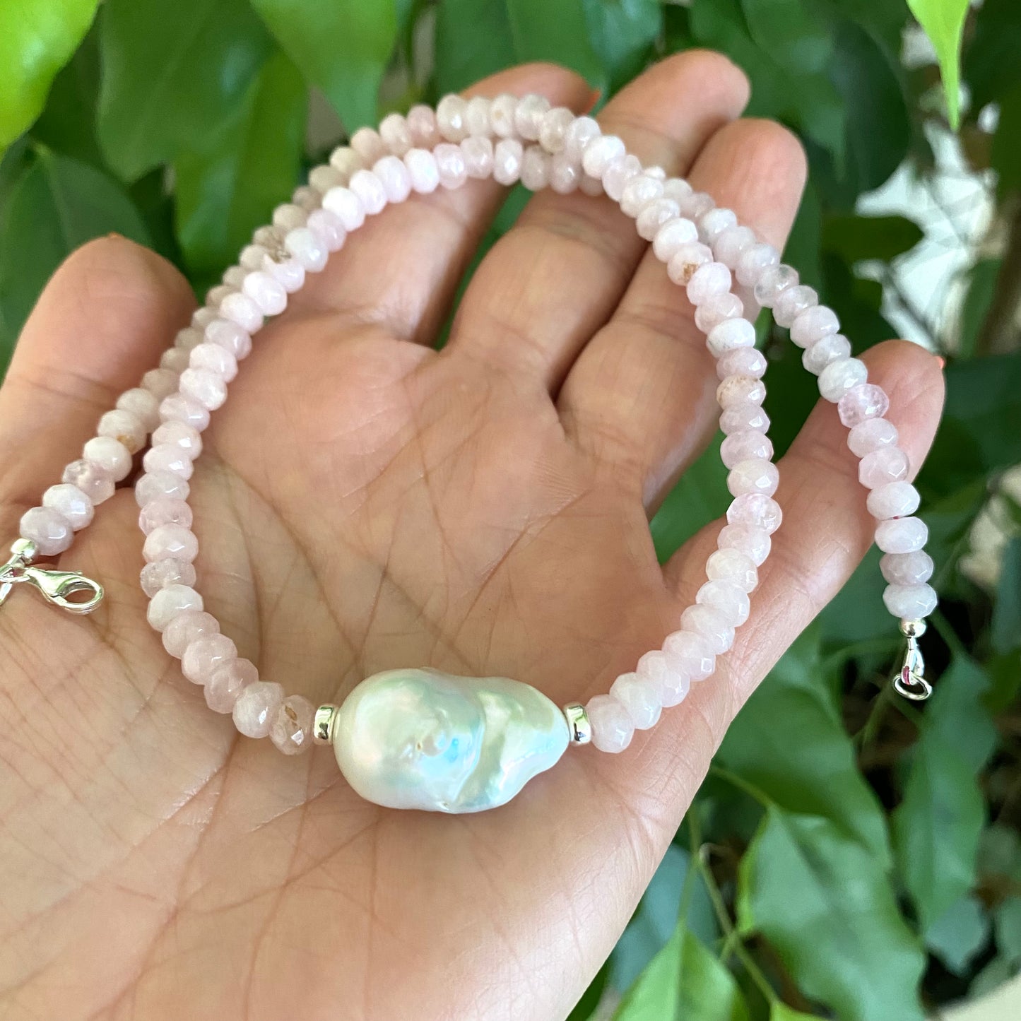 Rose quartz pearl necklace held in hand with faceted rose quartz and baroque pearl detail, handmade Canadian jewelry