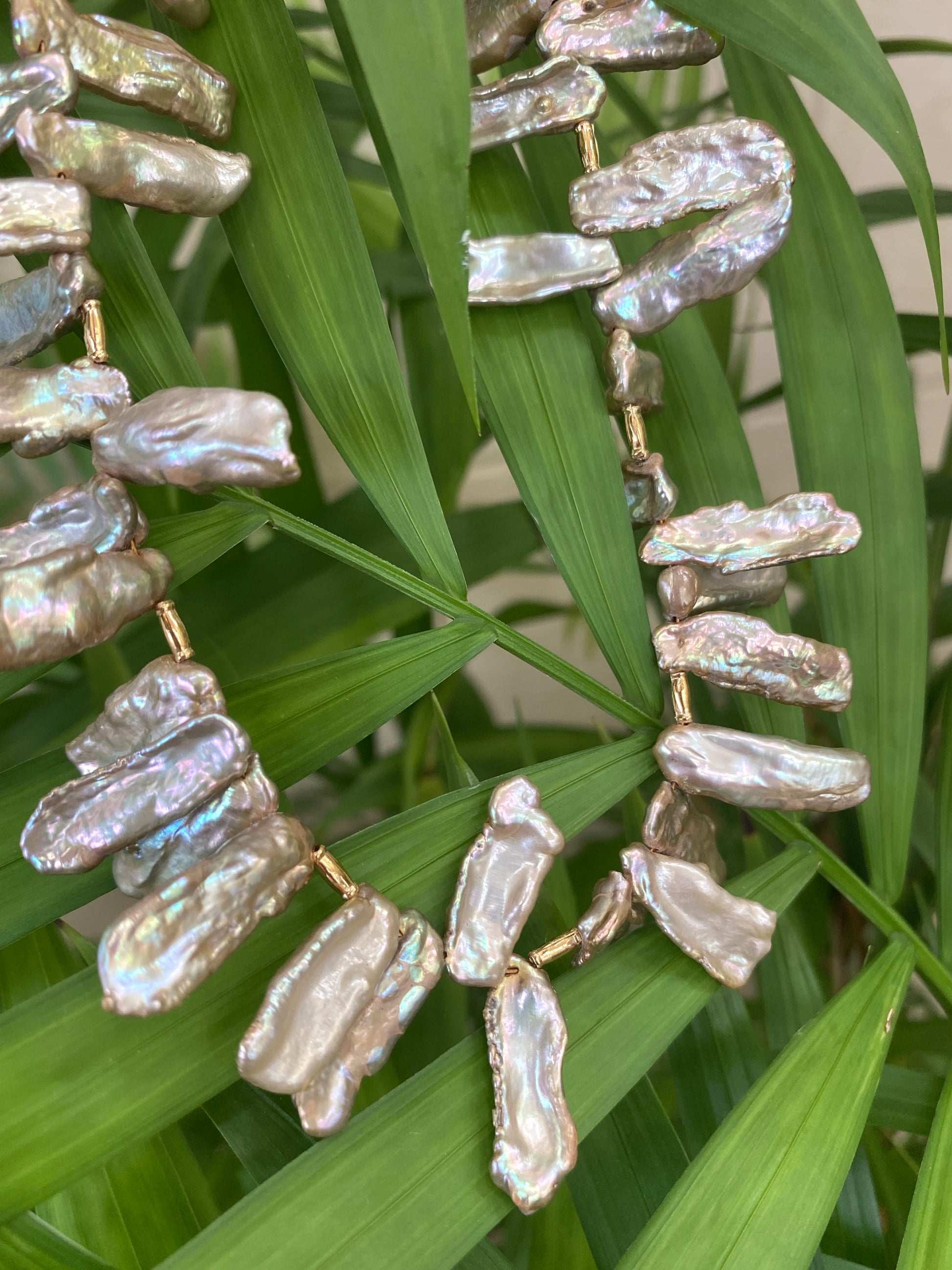 Champagne pearl necklace hanging on greenery, freshwater Biwa keshi pearls with golden tones