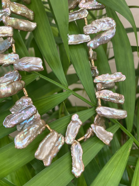 Champagne pearl necklace hanging on greenery, freshwater Biwa keshi pearls with golden tones