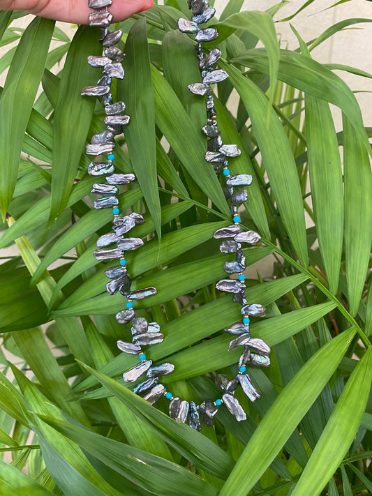 Biwa pearl turquoise necklace hanging on greenery, iridescent grey pearls and turquoise beads