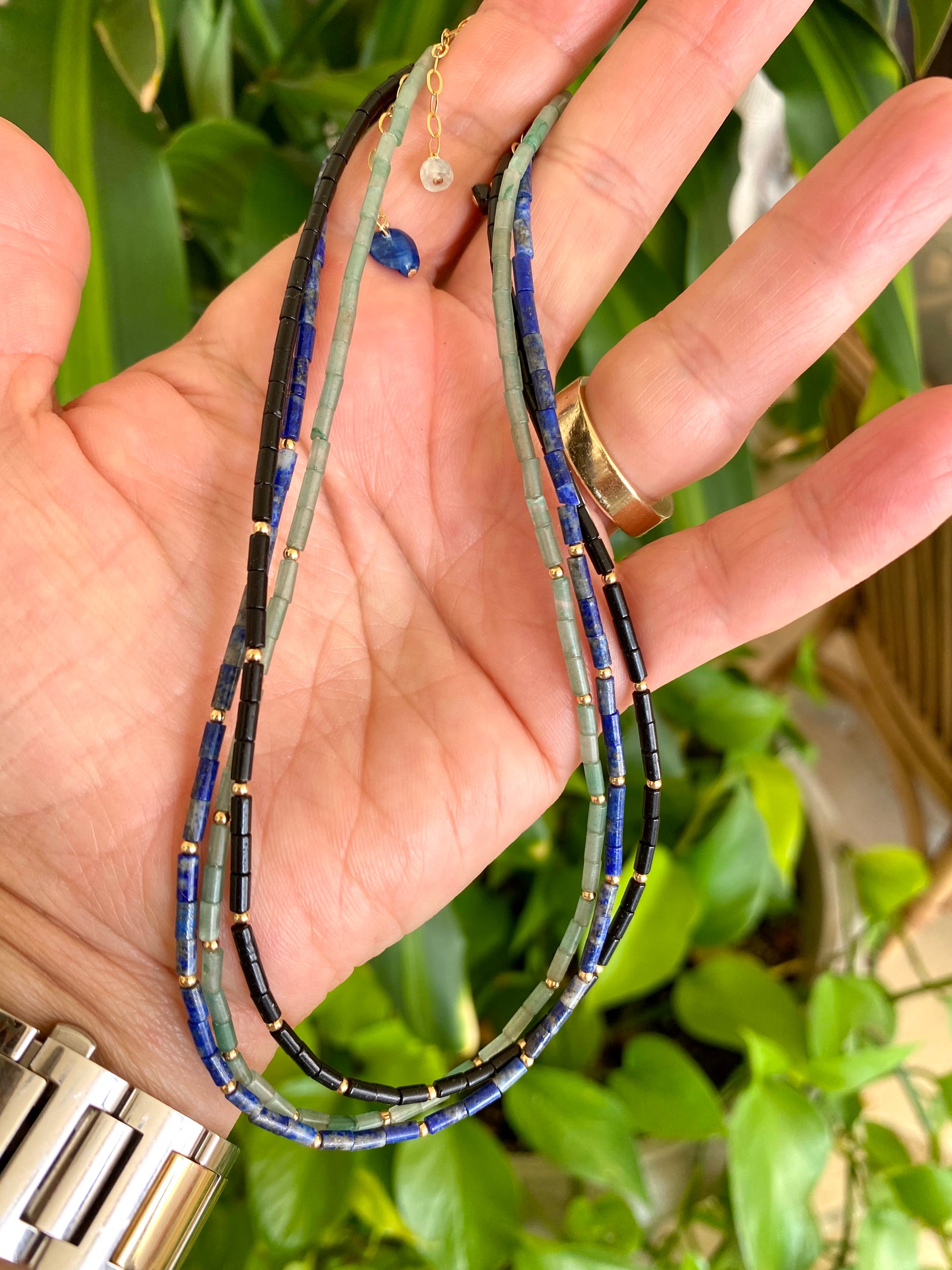 Lapis lazuli onyx choker necklace held in hand showing blue lapis gemstone beads