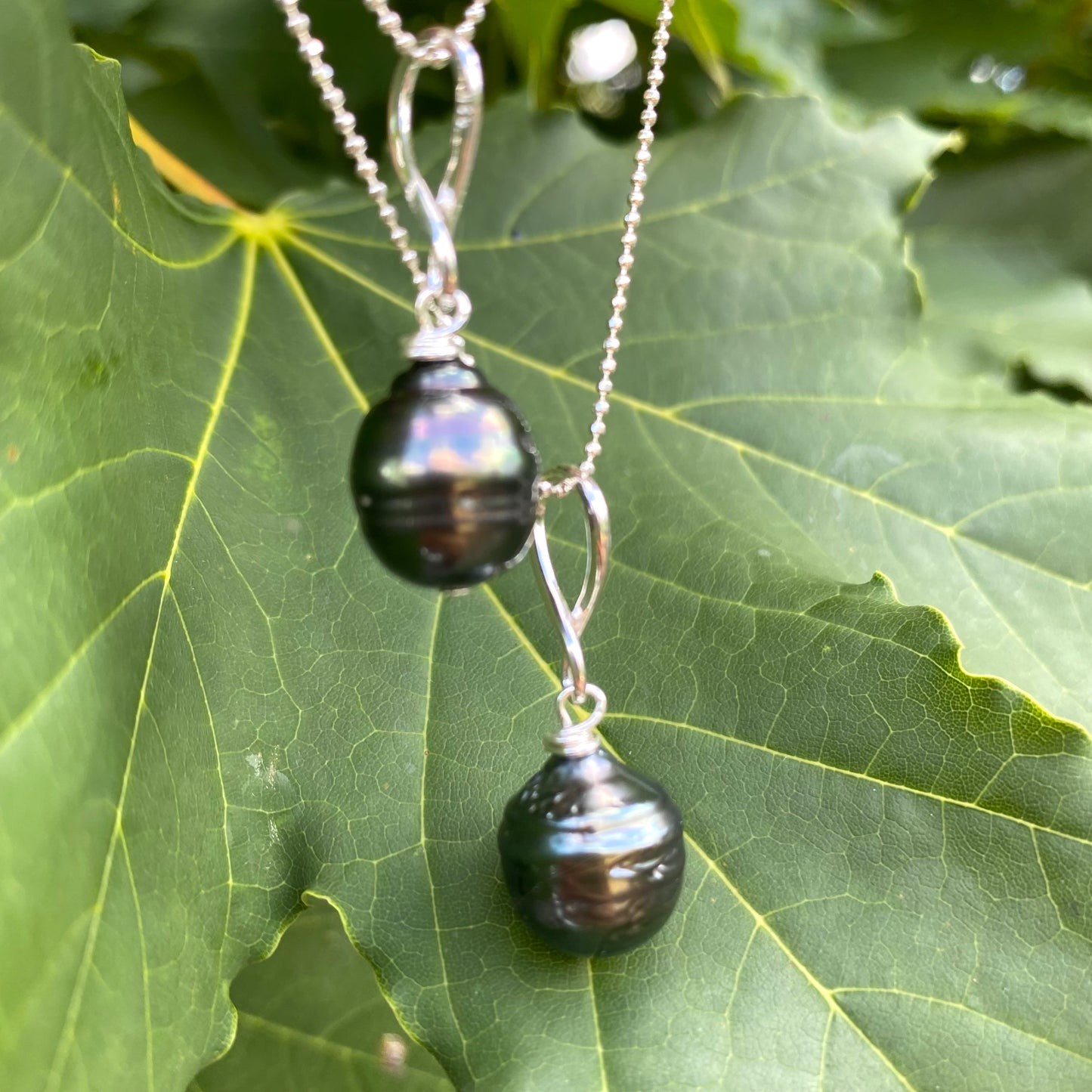 Tahitian teardrop pearl pendant necklace close-up, circled baroque Tahitian pearl on sterling silver chain