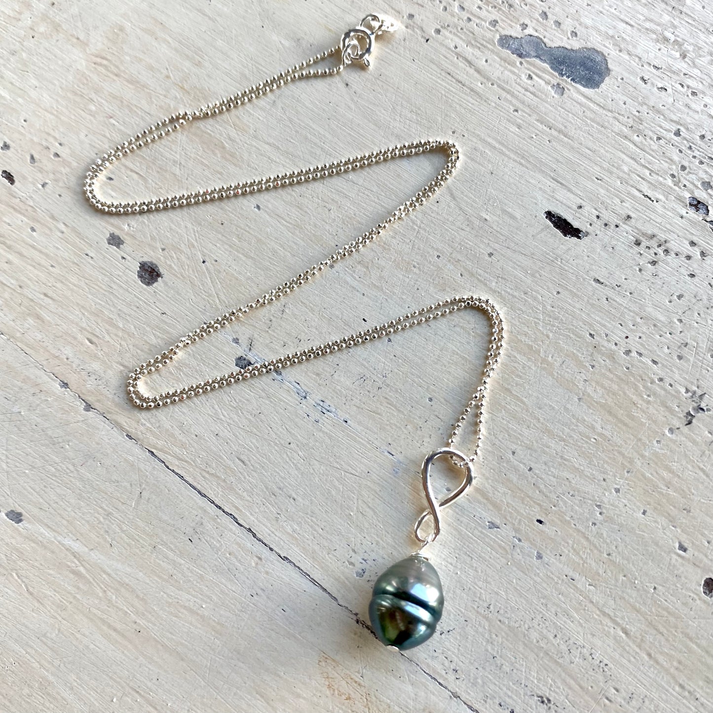 Tahitian teardrop pearl pendant necklace flat lay, sterling silver ball chain with Tahitian pearl pendant