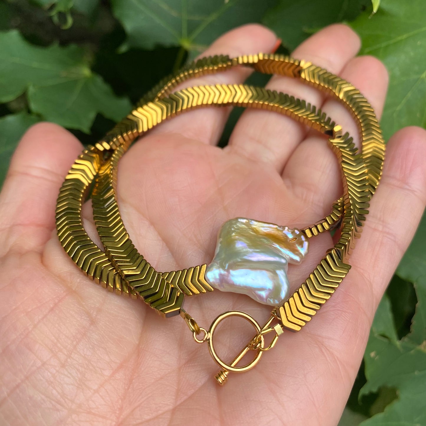 Gold hematite keshi pearl necklace showing structured V-shaped hematite beads and pearl