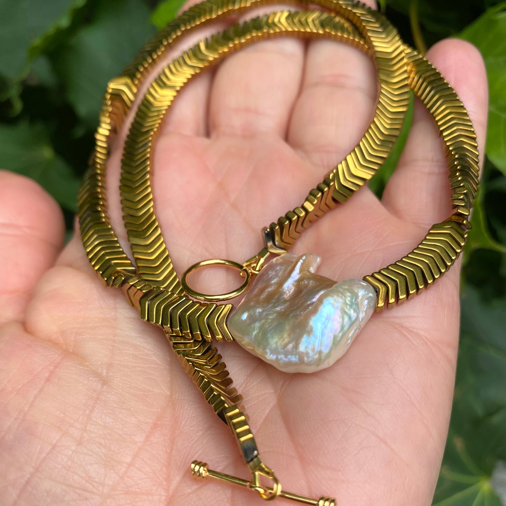 Gold hematite keshi pearl necklace photographed in hand emphasizing gold vermeil toggle clasp