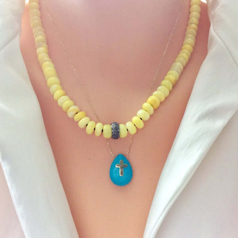 Yellow opal necklace with diamond accents displayed on a mannequin, featuring a turquoise teardrop pendant.