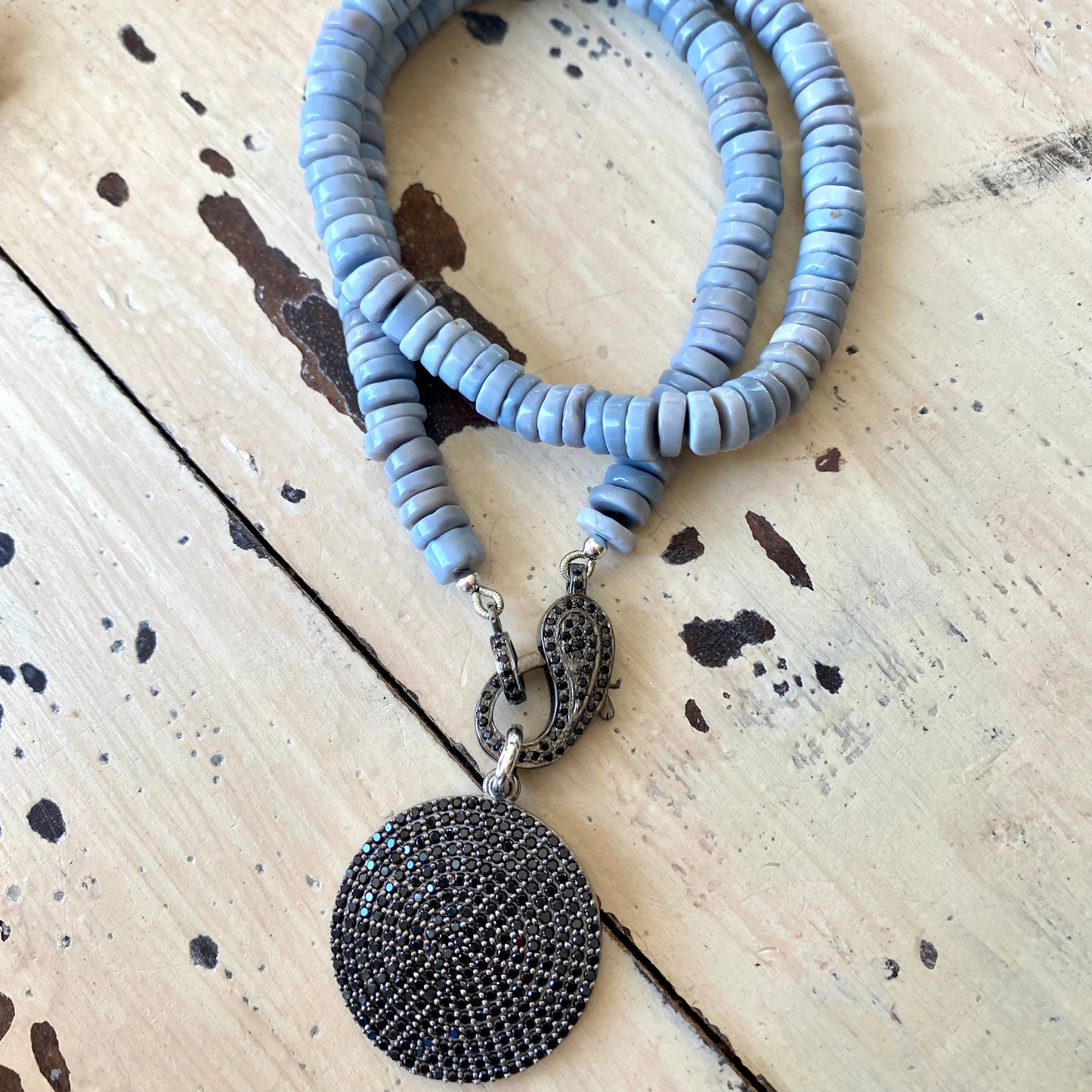 Oregon blue opal candy necklace laid flat with tire-shaped opal beads and black spinel pendant, handmade Canadian jewelry