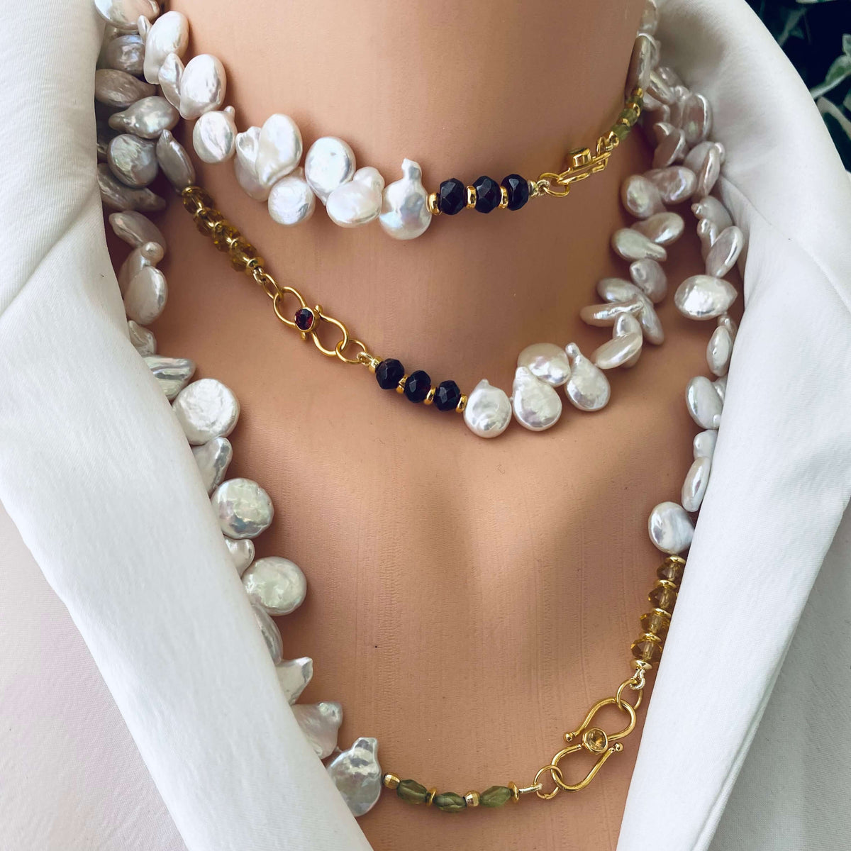 Keshi pearl necklace with garnet, citrine, and peridot showcased elegantly on a mannequin.