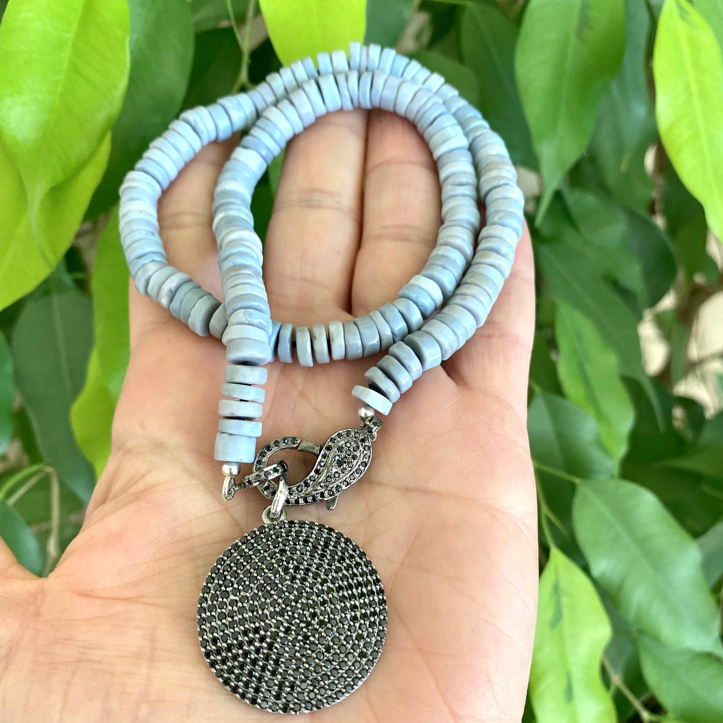 Oregon blue opal candy necklace held in hand with removable black spinel pavé pendant, handmade in Canada
